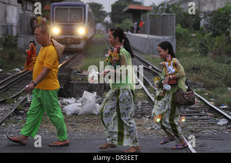 Manille, Philippines. 18 janvier, 2014. Manille, Philippines - Les participants traversent la Railroad après avoir pris part à la danse de rue connu localement comme Buling Buling Festival à Pandacan, Manille un jour avant la fête de la Sto. Nino, le 18 janvier 2014. La danse traditionnelle est organisée en l'honneur de la Sto. Nino qui a sauvé la ville de Pandacan d'être pulvérisé par les Espagnols durant l'époque coloniale. Crédit : George Calvelo/NurPhoto ZUMAPRESS.com/Alamy/Live News Banque D'Images