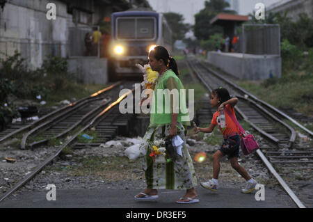 Manille, Philippines. 18 janvier, 2014. Manille, Philippines - Les participants traversent la Railroad après avoir pris part à la danse de rue connu localement comme Buling Buling Festival à Pandacan, Manille un jour avant la fête de la Sto. Nino, le 18 janvier 2014. La danse traditionnelle est organisée en l'honneur de la Sto. Nino qui a sauvé la ville de Pandacan d'être pulvérisé par les Espagnols durant l'époque coloniale. Crédit : George Calvelo/NurPhoto ZUMAPRESS.com/Alamy/Live News Banque D'Images