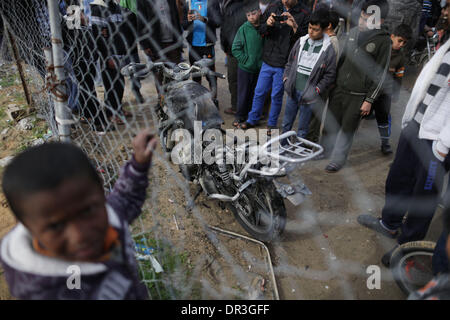 Gaza, Territoires palestiniens. 19 Jan, 2014. Inspecter les Palestiniens une moto endommagée après une frappe aérienne israélienne dans le nord de la ville de Gaza, le 19 janvier 2014. Un drone israélien a frappé une moto voyageant dans le nord de la bande de Gaza, blessant les rider, un passant, et tué un âne selon des témoins. Credit : Wissam Nassar/Xinhua/Alamy Live News Banque D'Images