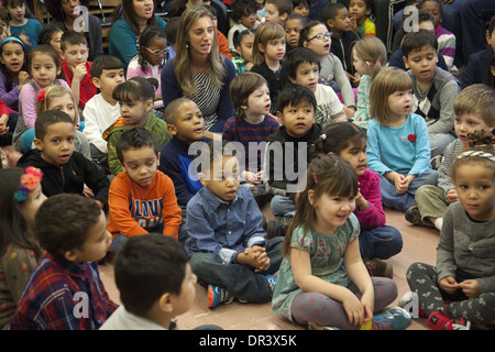 Les enfants, les enseignants et parents chanter ensemble chaque lundi matin à l'école primaire publique Pont Château, Manhattan, NYC Banque D'Images