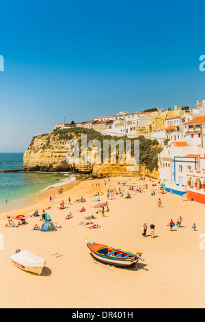 Les gens sur la plage, dans l'arrière-plan les maisons construites sur le rocher, Carvoeiro, Algarve, PORTUGAL Banque D'Images