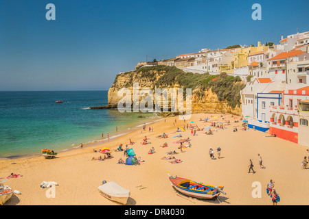 Les gens sur la plage, dans l'arrière-plan les maisons construites sur le rocher, Carvoeiro, Algarve, PORTUGAL Banque D'Images