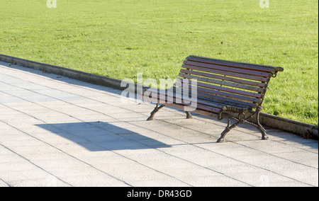Banc en bois dans le parc près de l'herbe sur sunny day Banque D'Images