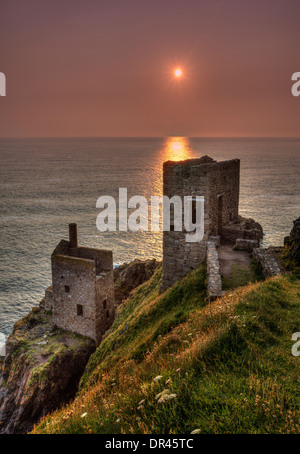 Ruine de la mine de la Couronne dans les falaises à Botallack, Cornwall, Angleterre, au coucher du soleil Banque D'Images