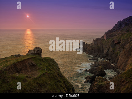 Ruine de la mine de la Couronne dans les falaises à Botallack, Cornwall, Angleterre, au coucher du soleil Banque D'Images