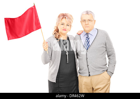 Couple d'âge moyen qui agitait un drapeau rouge Banque D'Images