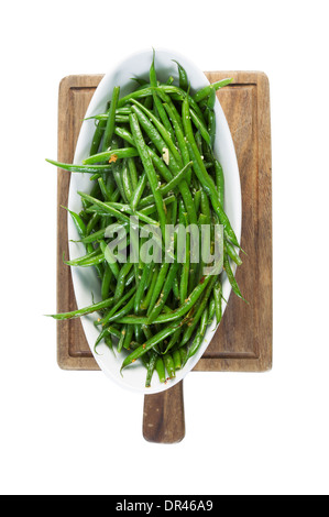 Photo verticale de fraîchement haricots verts cuits dans un bol blanc sur noir noyer administrateur isolated on white Banque D'Images