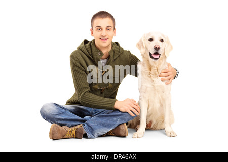 Jeune homme dans des vêtements décontractés assis sur le plancher avec son labrador retriever dog Banque D'Images