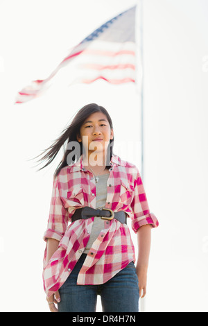Chinese girl smiling in front of American flag Banque D'Images