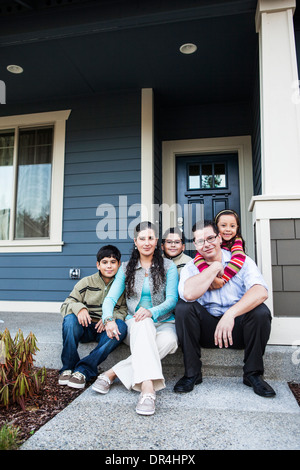 Family smiling sur avant stoop Banque D'Images