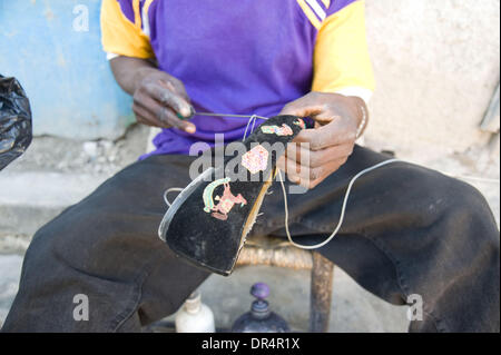 25 avr 2009 - Port-au-Prince, Haïti - un côté de la rue cordonnier répare un mesdames soulier sur une rue près de Delmas 65 à Port-au-Prince. (Crédit Image : © David Snyder/ZUMA Press) Banque D'Images