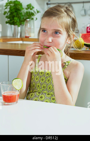 Fille assise à table dans la cuisine Banque D'Images