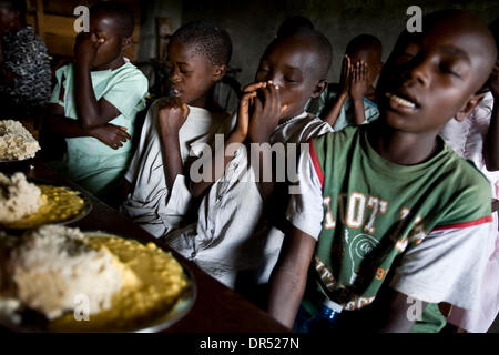 Dec 13, 2008 - Goma, République démocratique du Congo - enfants Congolais déplacés prier avant de manger un repas servi par l'école au Centre Chretien du lac Kivu, une église à l'ouest de Goma où plusieurs centaines de Congolais ont rassemblé dans un IDP (personnes déplacées à l'intérieur de fortune personne) camp. (Crédit Image : © T.J. Kirkpatrick/ZUMA Press) Banque D'Images