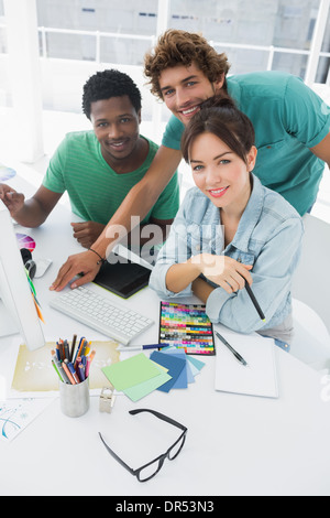 Portrait de trois artistes souriant au bureau Banque D'Images