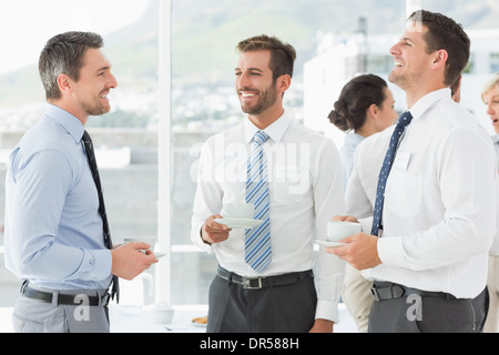 Des collègues en discussion avec des tasses de thé pendant les pauses Banque D'Images