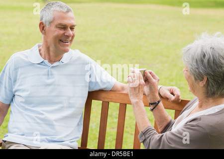 Senior woman photographing man at park Banque D'Images