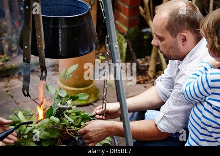 Père faisant feu dans jardin Banque D'Images