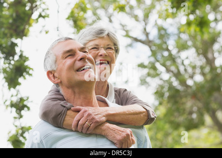 Senior woman embracing man de derrière Banque D'Images