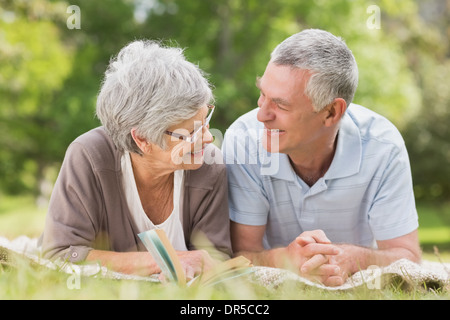 Smiling relaxed senior couple lying in park Banque D'Images