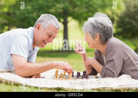 Happy senior couple jouant aux échecs dans le parc Banque D'Images