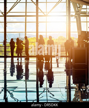 Silhouettes d'méconnaissable les gens du voyage à l'aéroport en face de l'immense fenêtre avec nature paysage en arrière-plan Banque D'Images