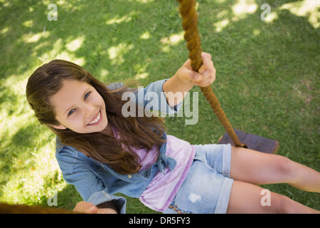 Cute little young girl sitting on swing Banque D'Images