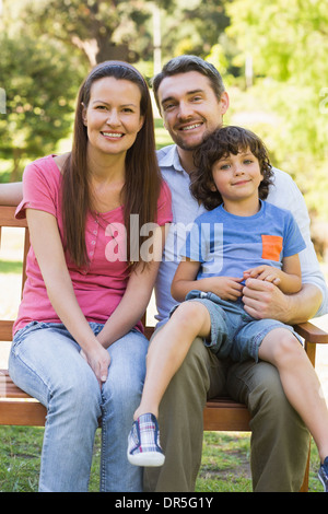 Smiling couple avec son sitting on park bench Banque D'Images