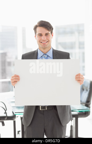 Handsome smiling businessman holding placard Banque D'Images