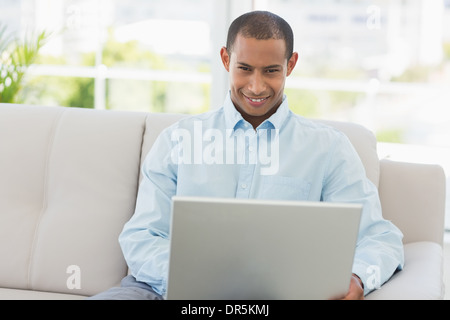 Smiling businessman working on laptop sur la table Banque D'Images