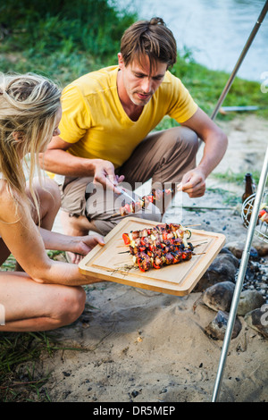 Un barbecue en couple au bord de la rivière, contreforts des Alpes, Bavière, Allemagne Banque D'Images