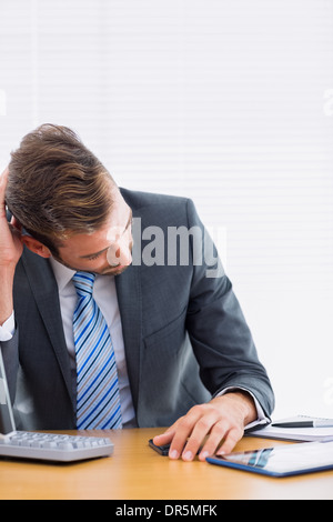 Thoughtful businessman sitting at office desk Banque D'Images