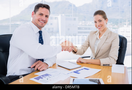 Smartly dressed colleagues shaking hands dans une réunion d'affaires Banque D'Images