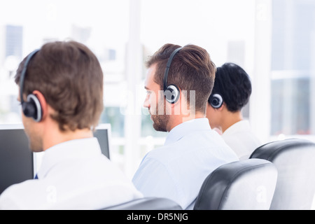 Des collègues d'affaires avec des écouteurs dans une rangée Banque D'Images