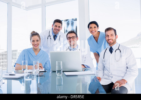 L'équipe médicale heureux using laptop together Banque D'Images