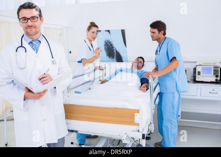 Doctors holding reports by patient at hospital Banque D'Images