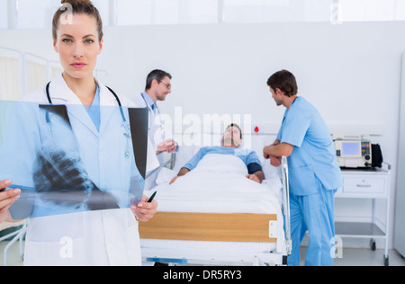 Doctor holding x-ray avec des collègues et des patients à l'hôpital Banque D'Images