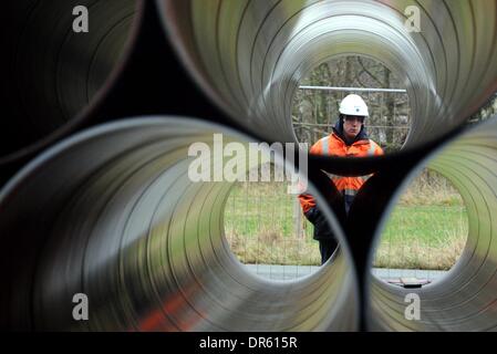Ellund, Allemagne. 20 Jan, 2014. Un employé se tient derrière les tuyaux pendant un nouveau pipeline de gaz naturel à l'ancien aérodrome en Ellund, Allemagne, 20 janvier 2014. L'Gasuni avec siège à Hanovre a l'intention d'utiliser le tuyau pour la construction d'un à environ 64 km de long gazoduc reliant Fockbek Ellund et dans le cadre du réseau transeuropéen de l'énergie. Photo : Carsten REHDER/dpa/Alamy Live News Banque D'Images