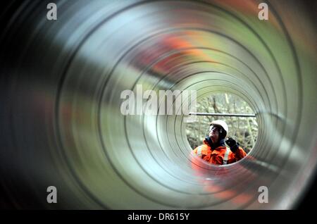 Ellund, Allemagne. 20 Jan, 2014. Un employé se tient derrière un tuyau d'un nouveau pipeline de gaz naturel à l'ancien aérodrome en Ellund, Allemagne, 20 janvier 2014. L'Gasuni avec siège à Hanovre a l'intention d'utiliser le tuyau pour la construction d'un à environ 64 km de long gazoduc reliant Fockbek Ellund et dans le cadre du réseau transeuropéen de l'énergie. Photo : Carsten REHDER/dpa/Alamy Live News Banque D'Images