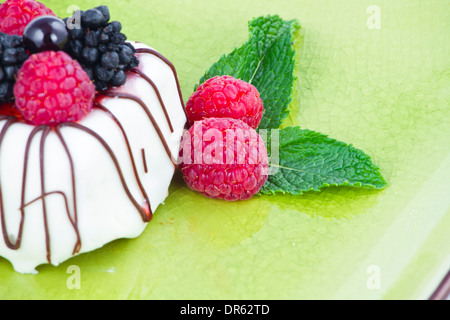 Chocolat noir et blanc avec des mûres sur plaque verte Banque D'Images