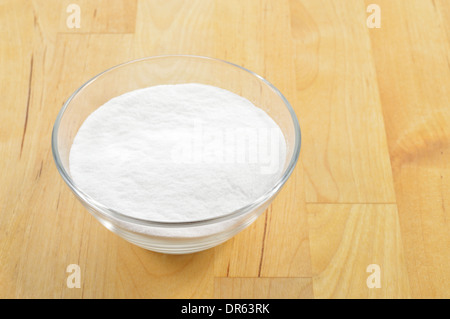 Close-up de bicarbonate de soude dans un bol en verre contre l'arrière-plan de table en bois. Le bicarbonate de soude. Banque D'Images