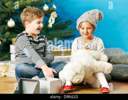 Enfants jouant avec des ours en peluche le soir de Noël, Munich, Bavière, Allemagne Banque D'Images