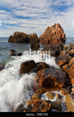 Vagues se briser dans des roches sur la plage Anse à Visitgrottan, Kullaberg / Kullen, Skåne, Suède Banque D'Images