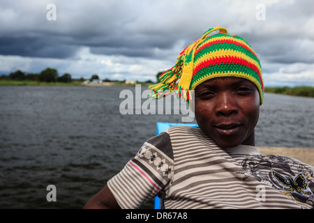 Portrait de jeune garçon africain avec Knit hat en bateau sur la rivière, dans la péninsule de l'Okavango, Botswana, Africa Banque D'Images