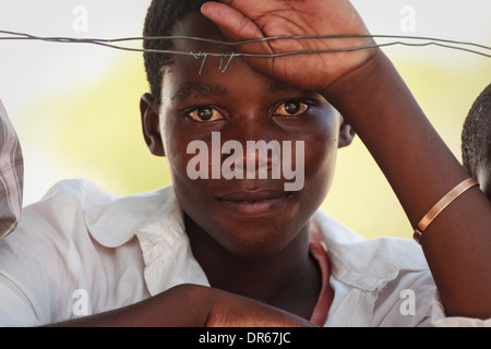 Portrait of teenage boy au Botswana, l'Afrique s'appuyant sur les barbelés Banque D'Images