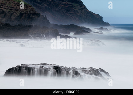 Moody longue exposition marins avec des vagues sur les rochers sur la côte de la Fajana La Palma, Îles Canaries, Espagne. Banque D'Images