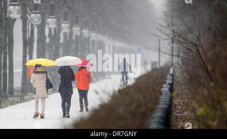 Berlin, Allemagne. Jan 21, 2014. Trois touristes coréens à pied avec des parasols comme il neige à Berlin, Allemagne, 21 janvier 2014. Photo : HANNIBAL/dpa/Alamy Live News Banque D'Images