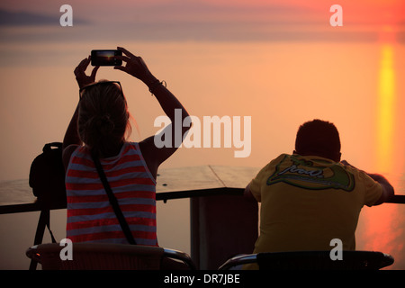 Europe Grèce cyclades sikinos un couple de prendre une photo du coucher de soleil Banque D'Images