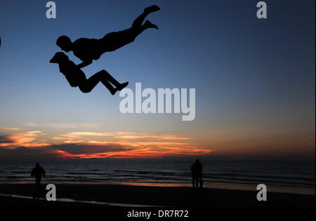 Gaza, Territoires palestiniens. Jan 21, 2014. Un jeune Palestinien effectue des cascades à la plage de la ville de Gaza avec ses amis pendant le coucher du soleil, le mar, 21, 2014. Credit : Majdi Fathi/NurPhoto ZUMAPRESS.com/Alamy/Live News Banque D'Images