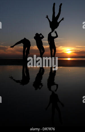 Gaza, Territoires palestiniens. Jan 21, 2014. Un jeune Palestinien effectue des cascades à la plage de la ville de Gaza avec ses amis pendant le coucher du soleil, le mar, 21, 2014. Credit : Majdi Fathi/NurPhoto ZUMAPRESS.com/Alamy/Live News Banque D'Images