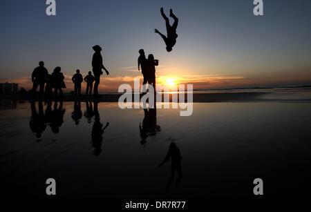 Gaza, Territoires palestiniens. Jan 21, 2014. Un jeune Palestinien effectue des cascades à la plage de la ville de Gaza avec ses amis pendant le coucher du soleil, le mar, 21, 2014. Credit : Majdi Fathi/NurPhoto ZUMAPRESS.com/Alamy/Live News Banque D'Images